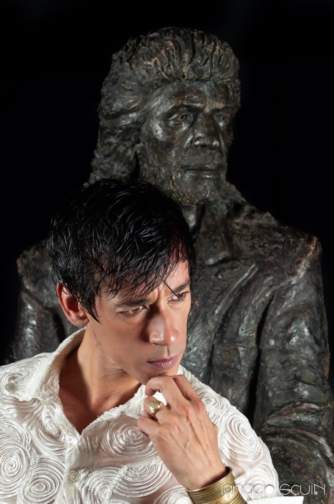 El Mawi pensativo junto a la estatua de Camarón de la Isla